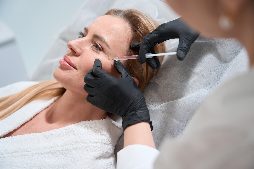 Female blonde gets a rejuvenating injection in her cheeks Female blonde gets a rejuvenating injection in her cheeks, an esthetician uses a thin needle